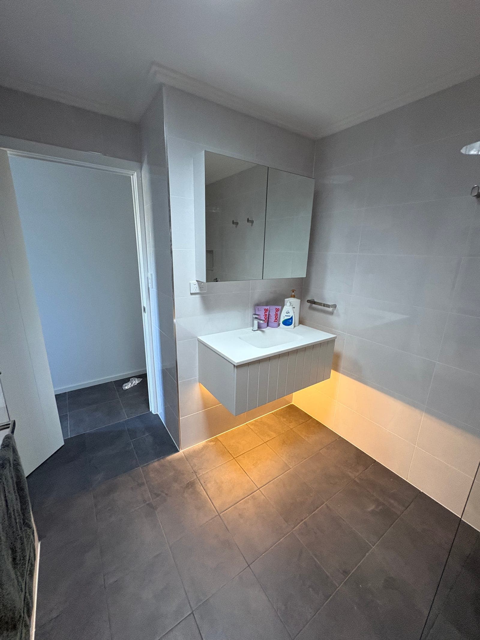 Bathroom mirror with backlit LED lighting installed during renovation